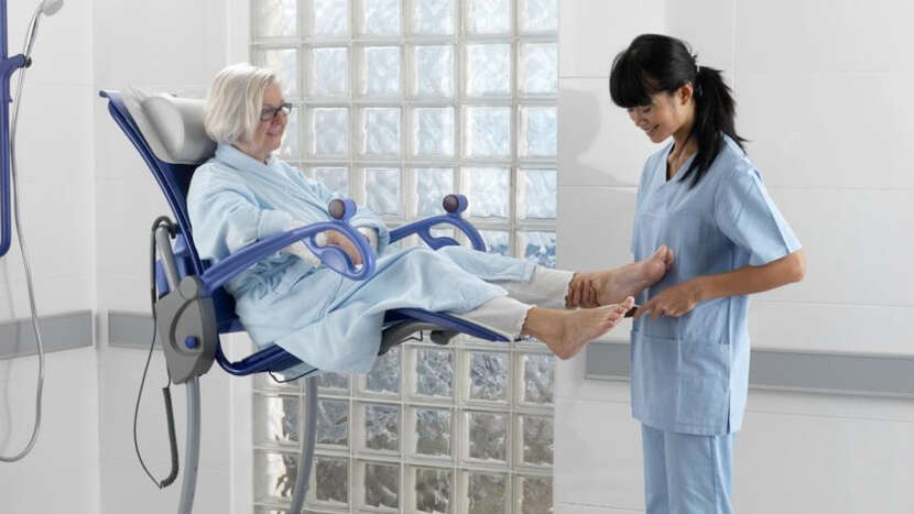ArjoHuntleigh-hygiene-systems-shower-chairs-caregiver-with-patient-on-Carino_Product_Page_Main_Image.jpg