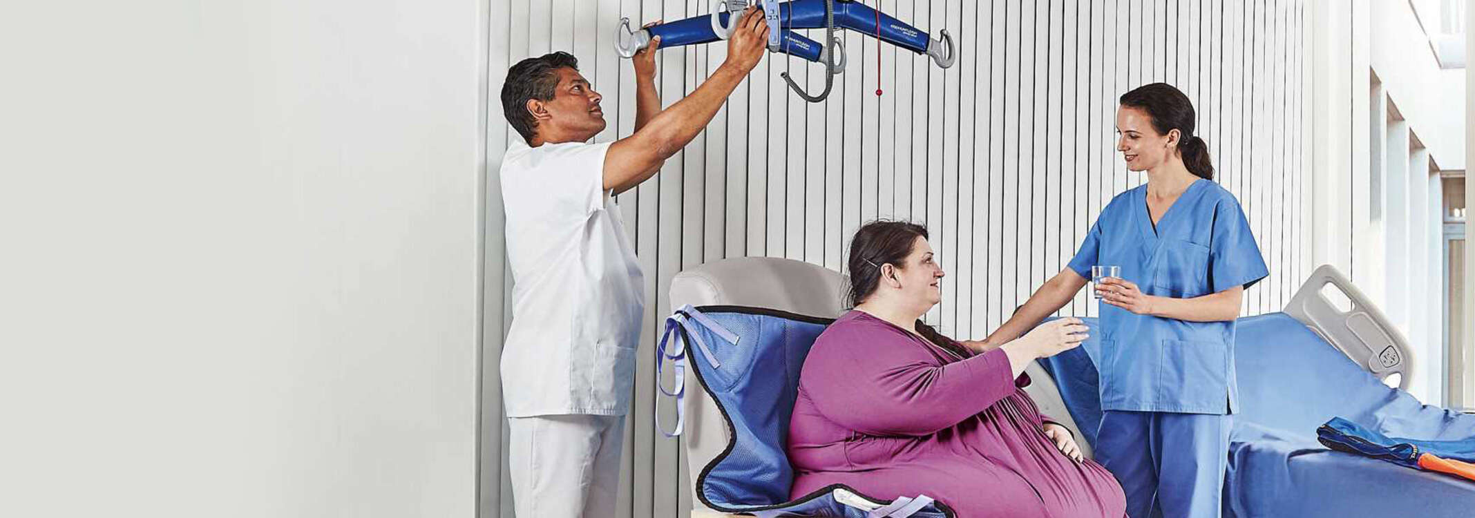 Stark übergewichtige Patientin mit zwei Pflegern und bariatrischem Krankenbett